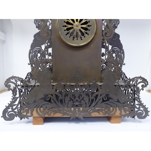 335 - A Continental fretworked brass cased mantel clock, featuring nude term figures, heraldic lions, flor... 