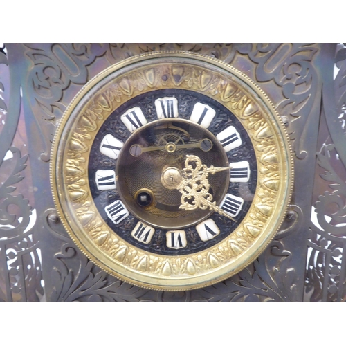 335 - A Continental fretworked brass cased mantel clock, featuring nude term figures, heraldic lions, flor... 