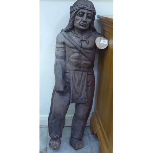 336 - A carved wooden figure, a Native American, wearing traditional costume  37