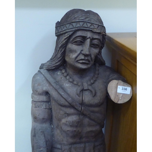 336 - A carved wooden figure, a Native American, wearing traditional costume  37