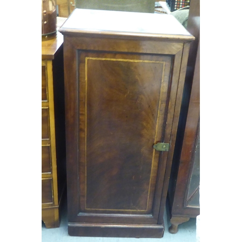 347 - A late Victorian mahogany pedestal cupboard with a door, enclosing a door and two drawers, on a plin... 