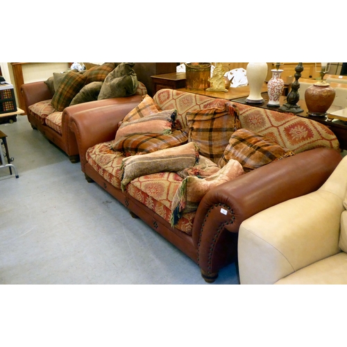 35 - A matched pair of modern two person settees with low, level backs and scrolled arms, part stud uphol... 