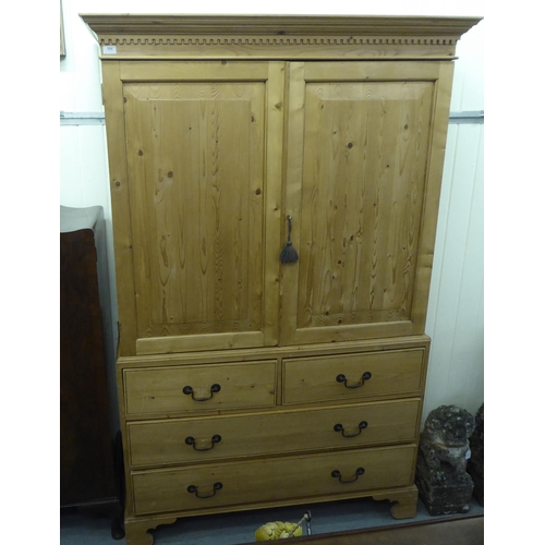 352 - A modern pine linen press with a cornice, over two doors, two short/two long drawers, raised on brac... 