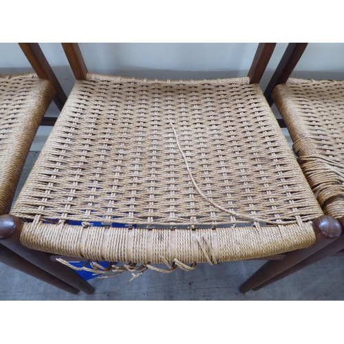 36 - A set of six 1970s teak framed panelled back dining chairs, the woven cane seats raised on turned le... 