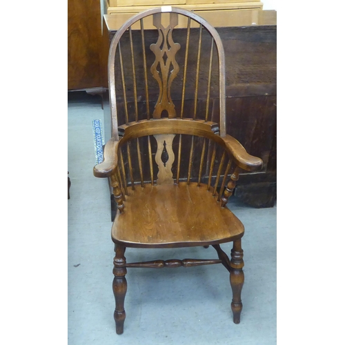 370 - A 20thC stained beech and oak framed high hoop, splat and spindle back Windsor arm chair, the solid ... 