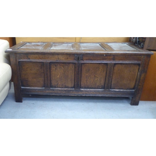 377 - A late 18thC panelled oak coffer with straight sides and a hinged lid  22