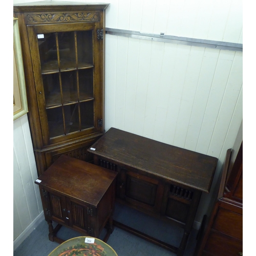 382 - Three items of 20thC Old English style oak furniture: to include a one piece, partially glazed corne... 