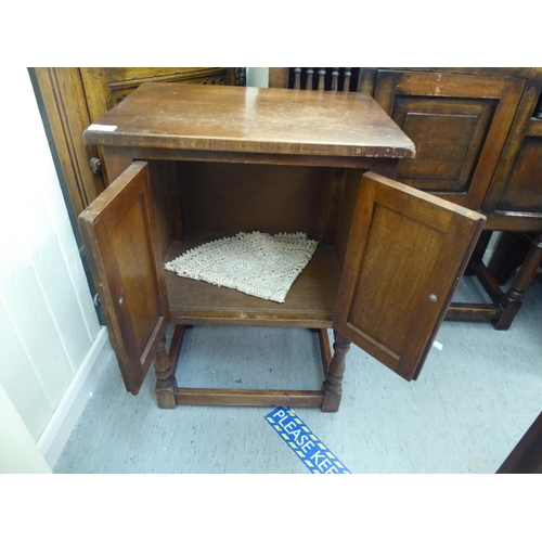 382 - Three items of 20thC Old English style oak furniture: to include a one piece, partially glazed corne... 