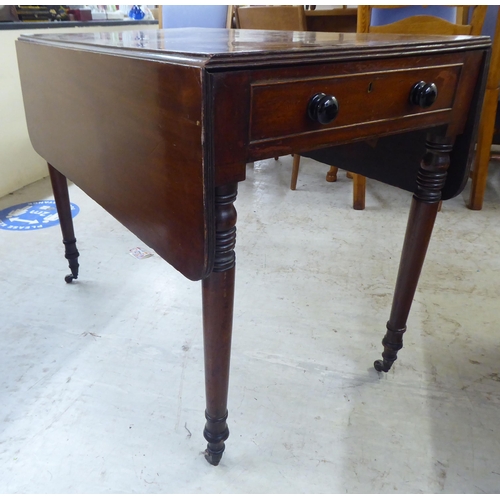 77 - A late 19thC mahogany Pembroke table, raised on turned legs and casters  28