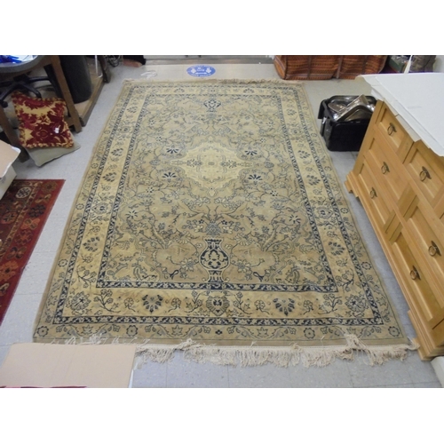 132 - A Persian design carpet, decorated with stylised flora and other designs, on a beige coloured backgr... 