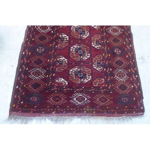 129 - A Turkoman rug, decorated with a single column of seven guls, on a red ground  44