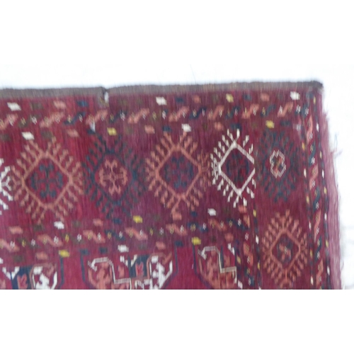 129 - A Turkoman rug, decorated with a single column of seven guls, on a red ground  44