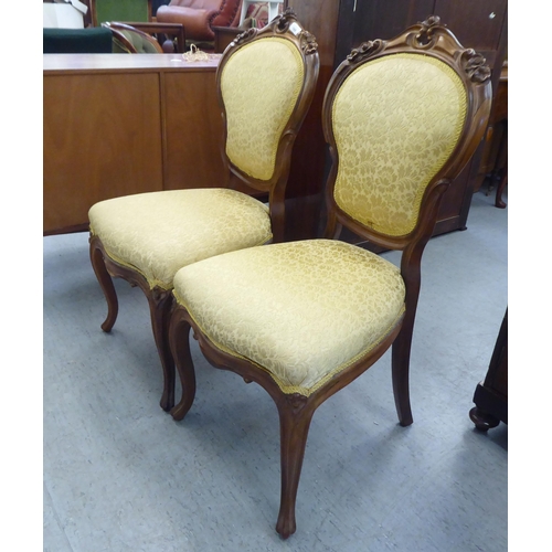 169 - A pair of Edwardian carved hardwood framed salon chairs with shield shape backs and braided old gold... 