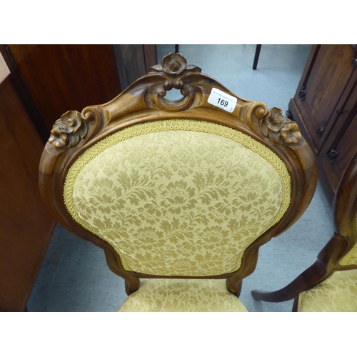 169 - A pair of Edwardian carved hardwood framed salon chairs with shield shape backs and braided old gold... 