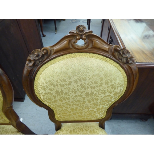 169 - A pair of Edwardian carved hardwood framed salon chairs with shield shape backs and braided old gold... 