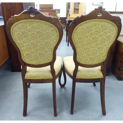 169 - A pair of Edwardian carved hardwood framed salon chairs with shield shape backs and braided old gold... 