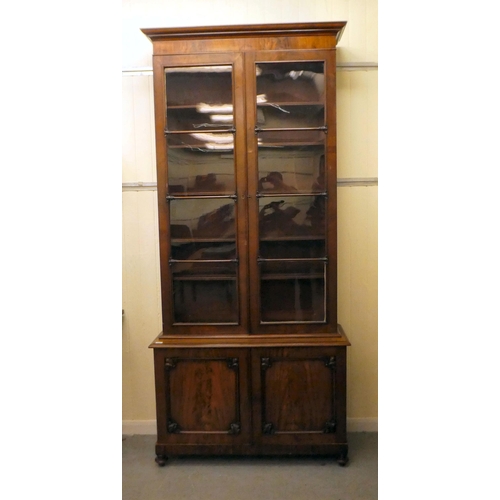 170 - A late Victorian mahogany cabinet bookcase with a straight cornice, over a pair of full-height, carv... 