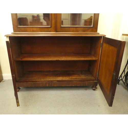 170 - A late Victorian mahogany cabinet bookcase with a straight cornice, over a pair of full-height, carv... 