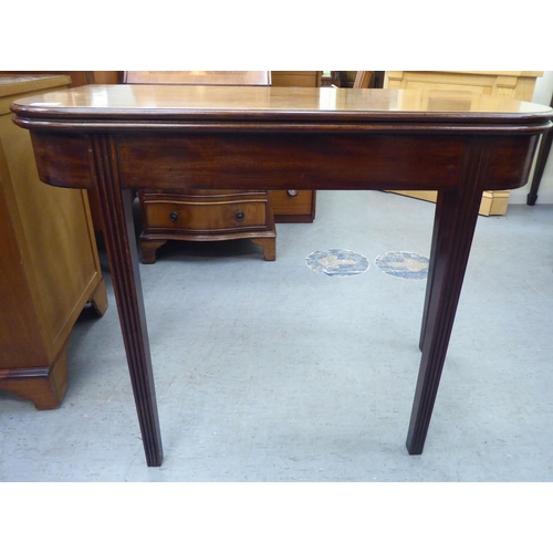 175 - A late Georgian mahogany D-shape tea table with a foldover top, raised on reed moulded, tapered legs... 