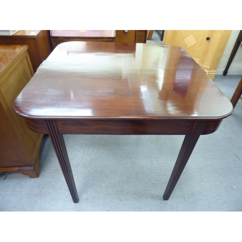 175 - A late Georgian mahogany D-shape tea table with a foldover top, raised on reed moulded, tapered legs... 