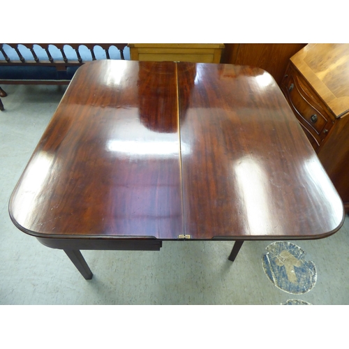 175 - A late Georgian mahogany D-shape tea table with a foldover top, raised on reed moulded, tapered legs... 