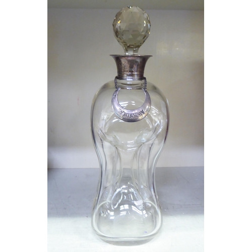 188 - A clear glass cluck-cluck decanter with an applied silver collar, facet cut stopper and white metal,... 