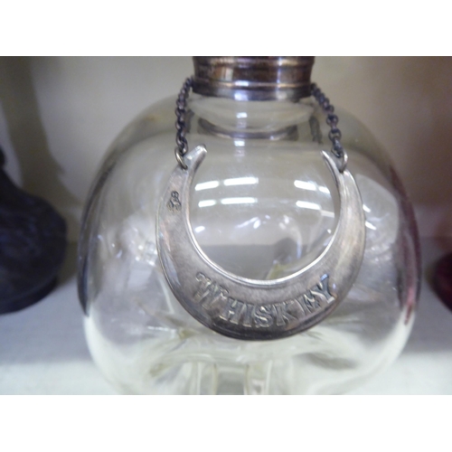 188 - A clear glass cluck-cluck decanter with an applied silver collar, facet cut stopper and white metal,... 