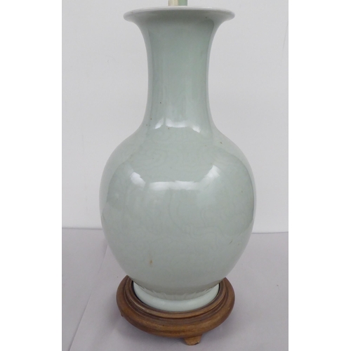 19 - A mid 20thC Chinese celadon glazed porcelain table lamp with a twin branch, height adjustable neck  ... 