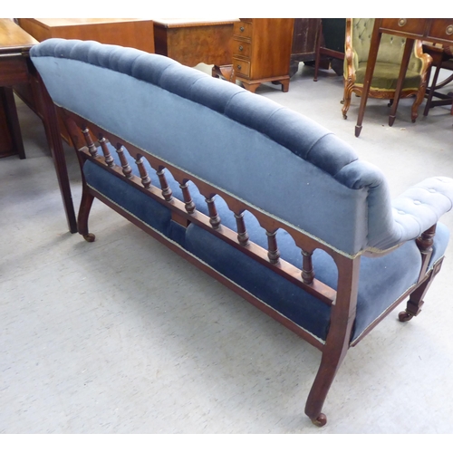 194 - An Edwardian mahogany showwood framed salon settee with a curved back and open arms, part button uph... 