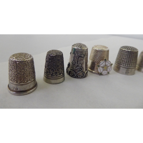 195 - A silver combination reel and thimble case; and various silver/white metal and other thimbles 