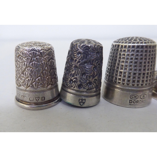 195 - A silver combination reel and thimble case; and various silver/white metal and other thimbles 