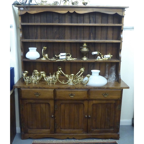 196 - A modern traditional style oak two part dresser, the superstructure with three open fixed shelves, o... 