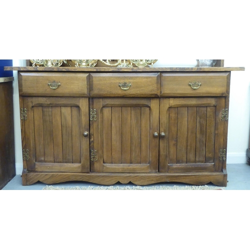 196 - A modern traditional style oak two part dresser, the superstructure with three open fixed shelves, o... 