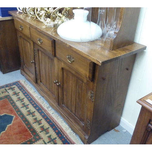 196 - A modern traditional style oak two part dresser, the superstructure with three open fixed shelves, o... 