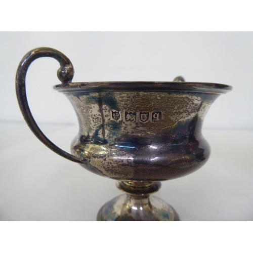 234 - Silver tableware: to include a one pint tankard; a twin handled pedestal trophy cup  5