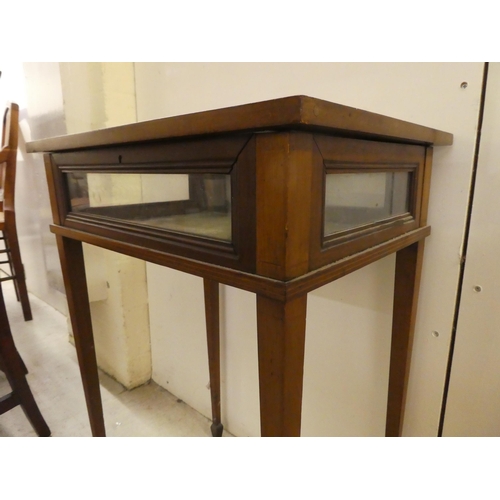 246 - An Edwardian mahogany fully glazed display table, the box top enclosed by a hinged lid, raised on sq... 