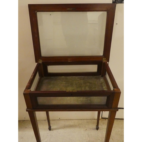 246 - An Edwardian mahogany fully glazed display table, the box top enclosed by a hinged lid, raised on sq... 