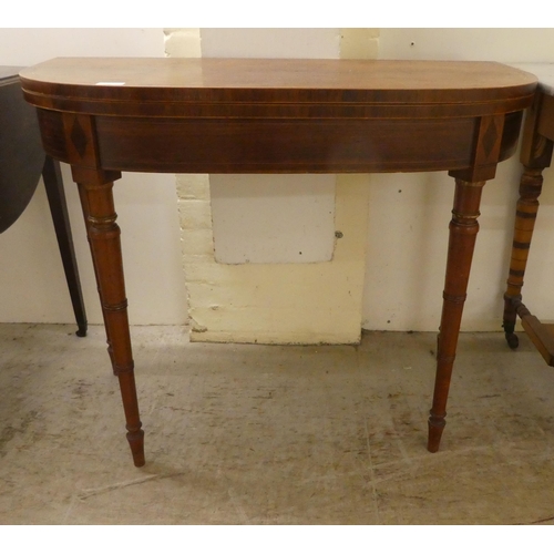 252 - An early 19thC rosewood demi-lune card table, the foldover top raised on ring turned, tapered legs, ... 