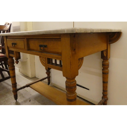 292 - An Edwardian satinwood washstand with a grey marble top, two drawers and a platform undershelf ... 