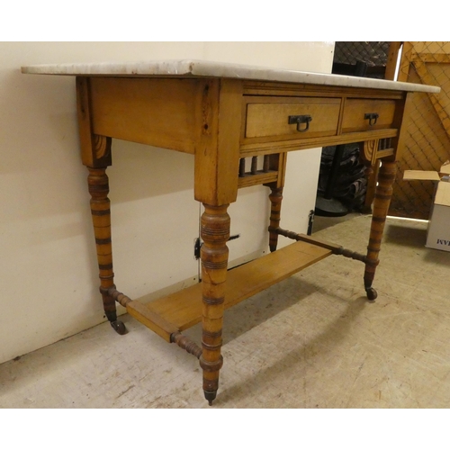 292 - An Edwardian satinwood washstand with a grey marble top, two drawers and a platform undershelf ... 