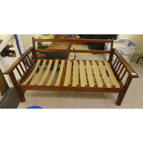 297 - A 1970/80s mahogany finished bed settee with a slatted pull-out end, raised on block feet