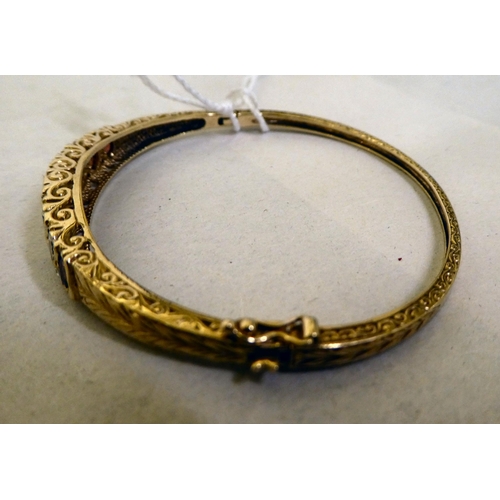 311 - A 9ct gold hinged bangle, set with diamonds and garnets 