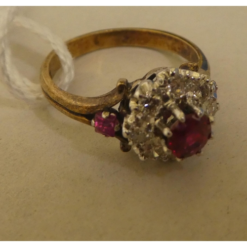 314 - A bi-coloured metal ruby and diamond cluster ring  stamped 18k