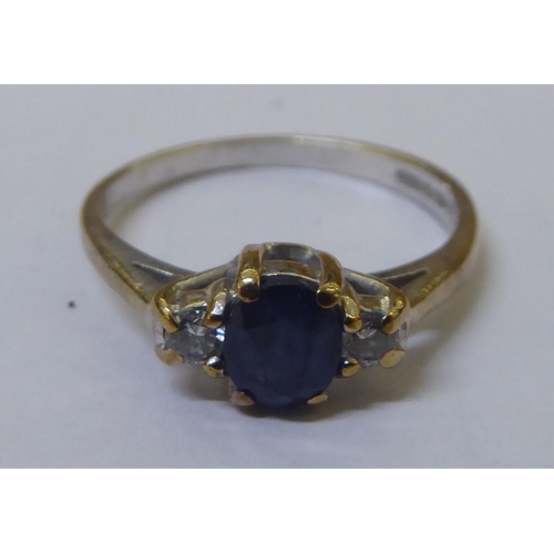 317 - A 9ct white gold claw set sapphire ring, flanked by two diamonds 