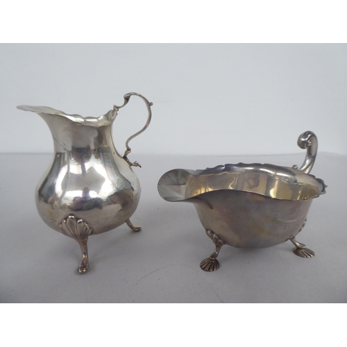 62 - Silver items, viz. a bulbous cream jug with a double C-scrolled handle; a sauce boat, elevated on sh... 