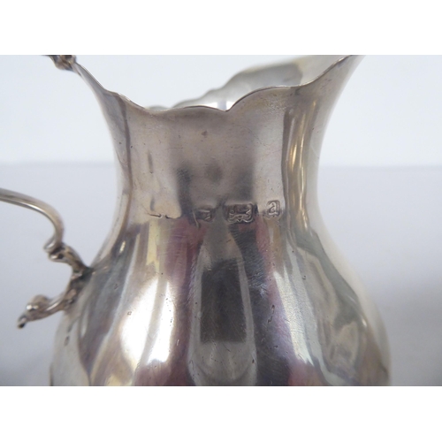 62 - Silver items, viz. a bulbous cream jug with a double C-scrolled handle; a sauce boat, elevated on sh... 