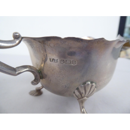 62 - Silver items, viz. a bulbous cream jug with a double C-scrolled handle; a sauce boat, elevated on sh... 