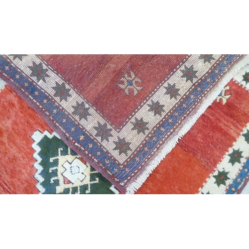 80 - A Turkish rug, decorated with three diamond motifs, on a mainly red ground  54