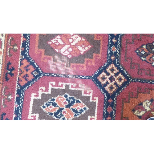 83 - A Persian design woollen carpet, decorated with repeating box design, stylised motif centre, bordere... 