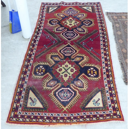 89 - Three small rugs: to include a Persian example, on a multi-coloured ground  47